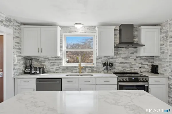 a kitchen with stainless steel appliances a stove sink microwave and cabinets