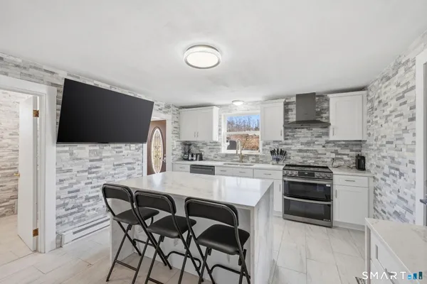 a kitchen with a table chairs a sink dishwasher and cabinets