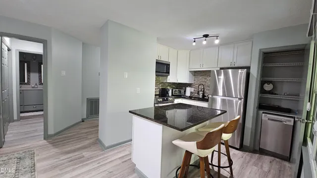 a kitchen with stainless steel appliances granite countertop a refrigerator and a sink