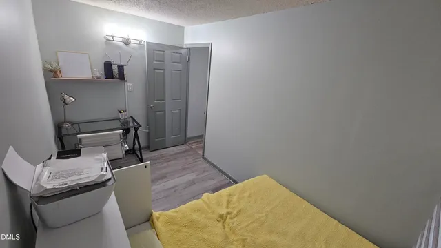 a view of a livingroom with wooden floor and a bathroom