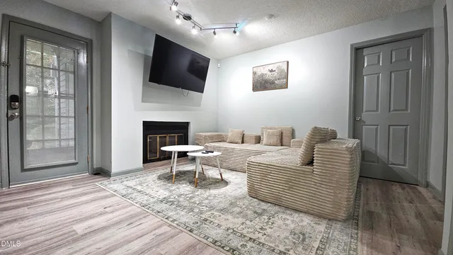 a living room with furniture a flat screen tv and a fireplace