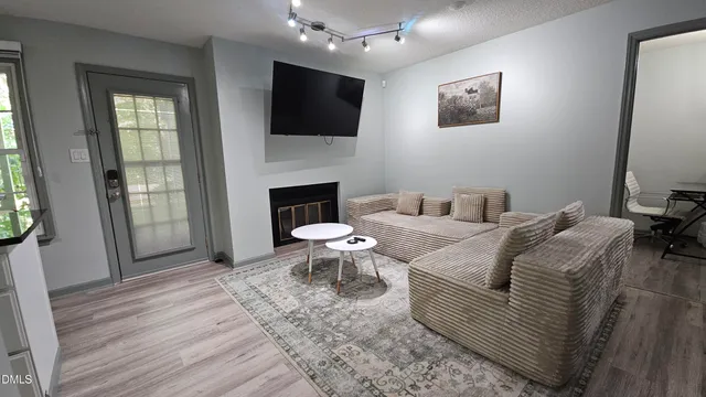 a living room with furniture a fireplace and a flat screen tv