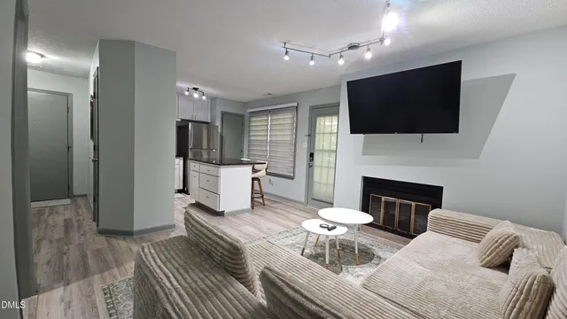 a living room with furniture a fireplace and a flat screen tv