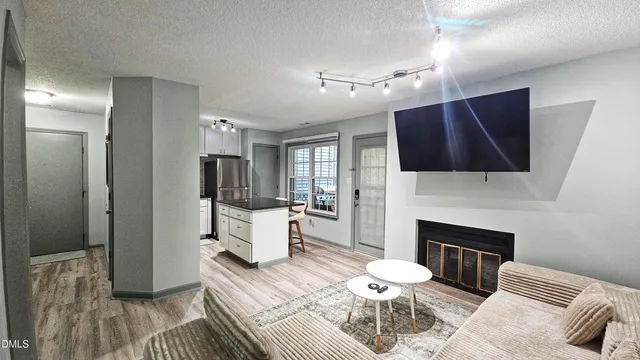 a living room with furniture a flat screen tv and a fireplace