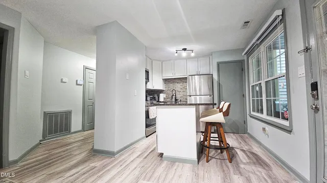 a view of a dining room with furniture a rug and wooden floor