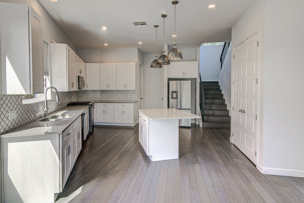 2406 East 16th Street Austin, TX 78702 - Photo 16 of 39 a kitchen with a white cabinets sink and refrigerator