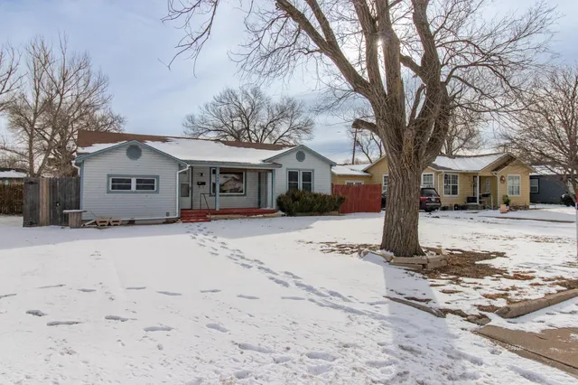 a front view of a house with a yard covered in snow