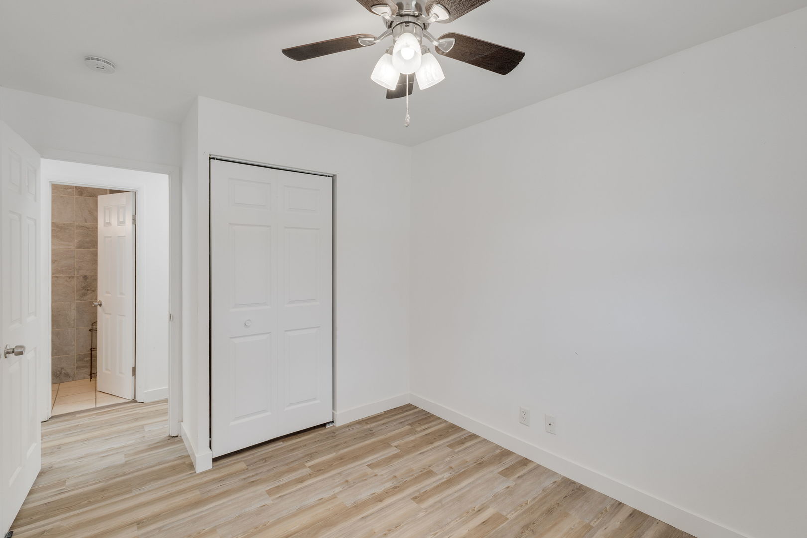 533 Redwood Road Bolingbrook, IL 60440 - Photo 11 of 18 an empty room with wooden floor closet chandelier fan and windows