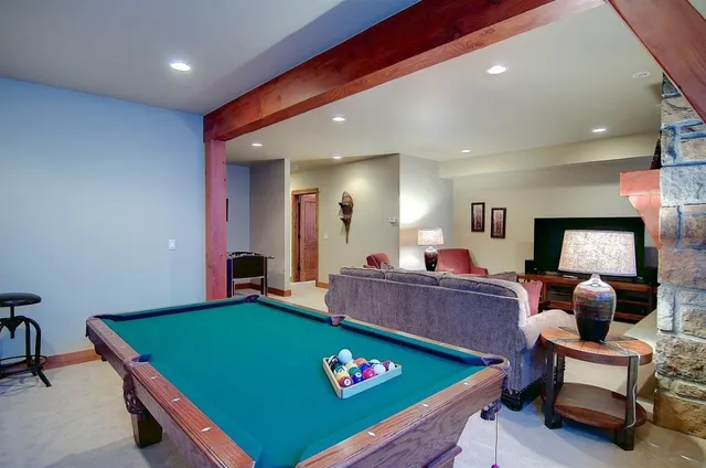 a living room with furniture pool table and window