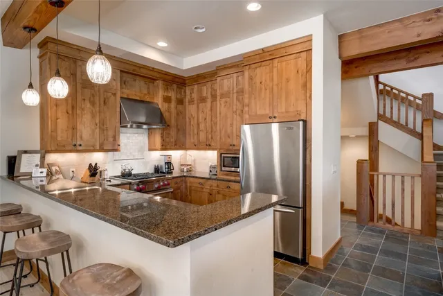 a kitchen with stainless steel appliances granite countertop a sink refrigerator and cabinets