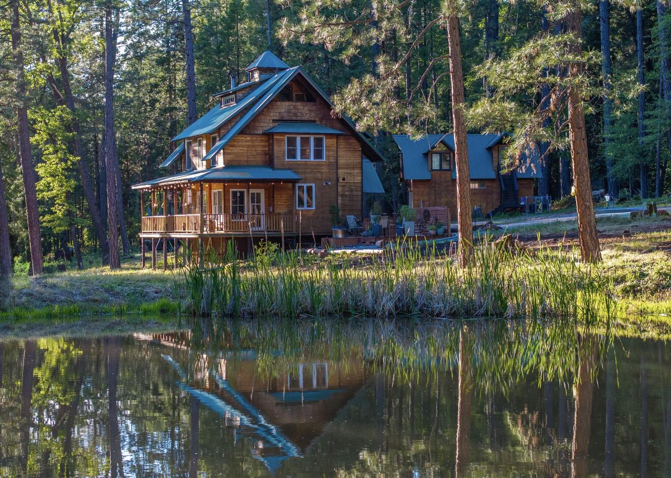 7704 Eastmoore Road Shingletown, CA 96088 - Photo 2 of 30 a view of a house next to a lake with a large trees