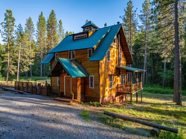 a view of small house with yard and sitting area
