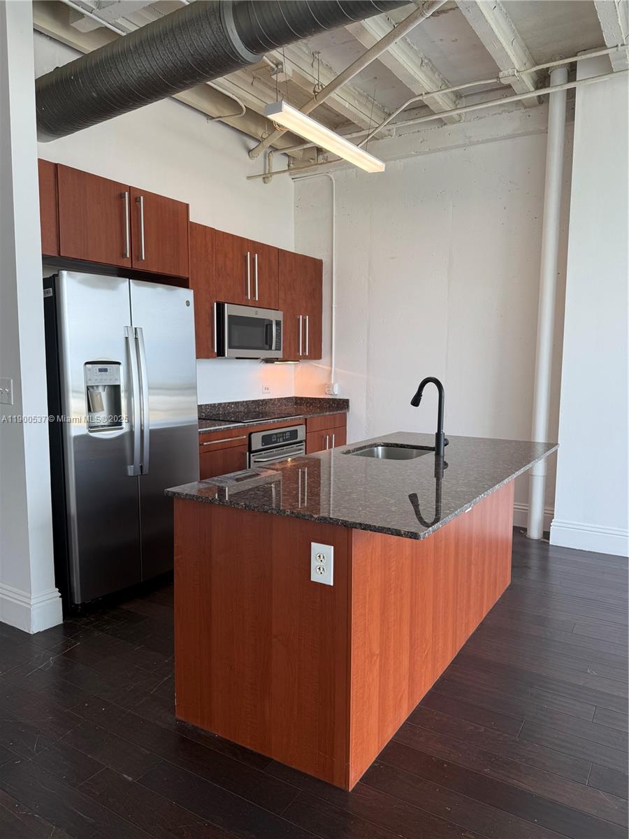 8101 Biscayne Boulevard, Unit R514 Miami, FL 33138 - Photo 2 of 11 a large kitchen with stainless steel appliances granite countertop a stove a refrigerator and a sink with wooden floor