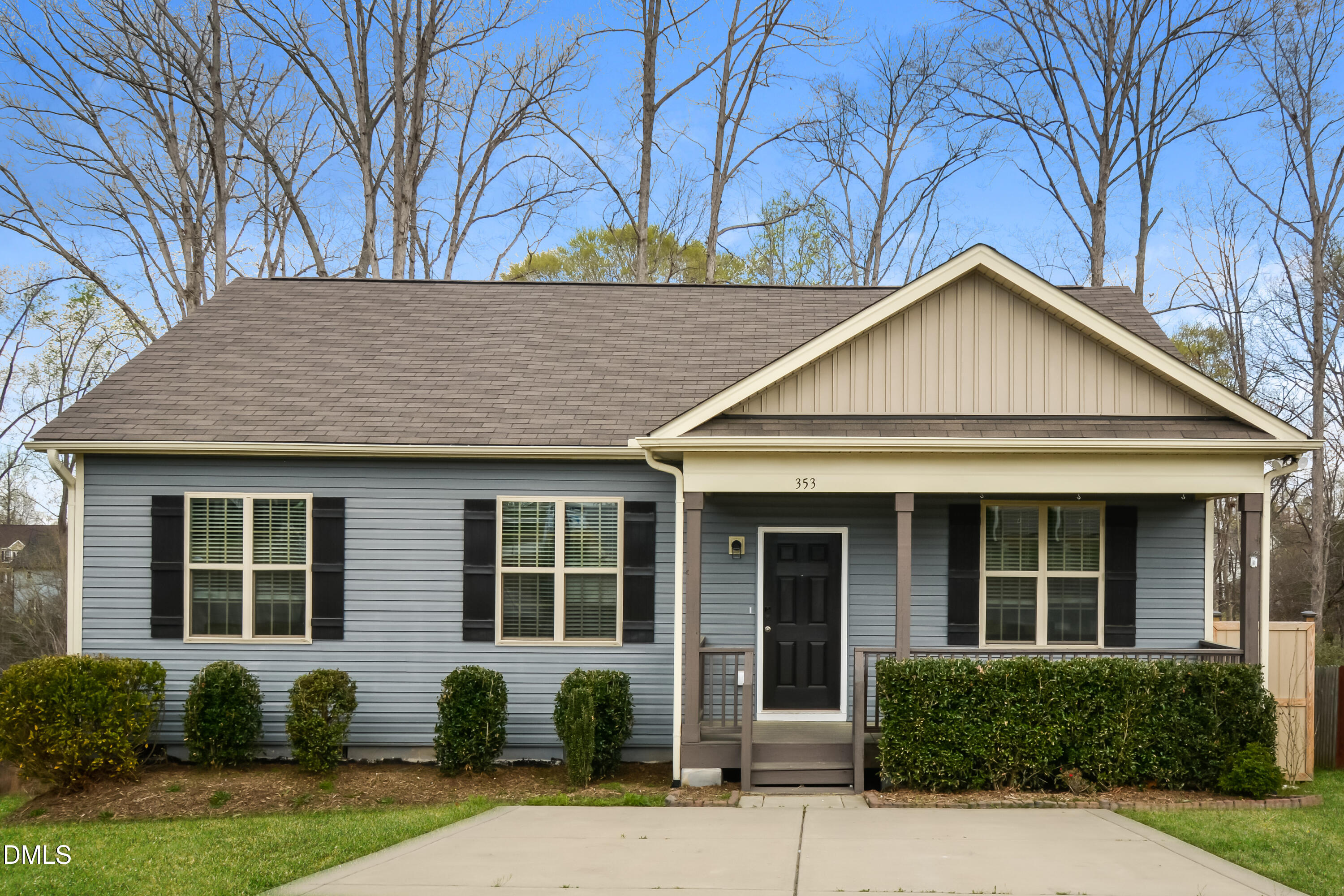 a front view of a house with a yard and potted plants