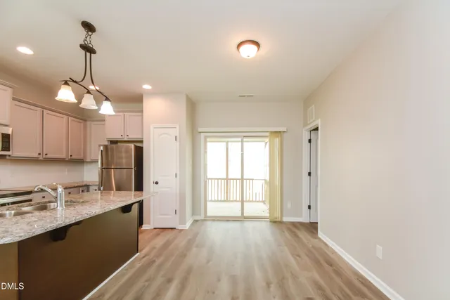 a view of a kitchen with a sink and dishwasher with wooden floor