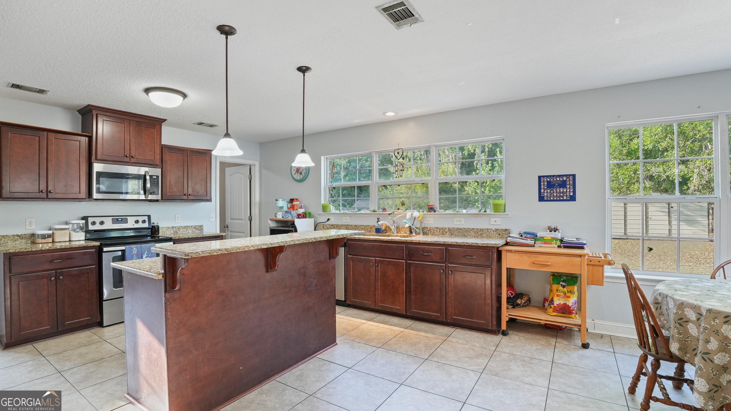 258 Nashview Trail Allenhurst, GA 31301 - Photo 19 of 40 a kitchen with stainless steel appliances granite countertop wooden cabinets a stove a sink dishwasher and a wooden cabinets