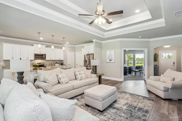 a living room with furniture and a view of kitchen