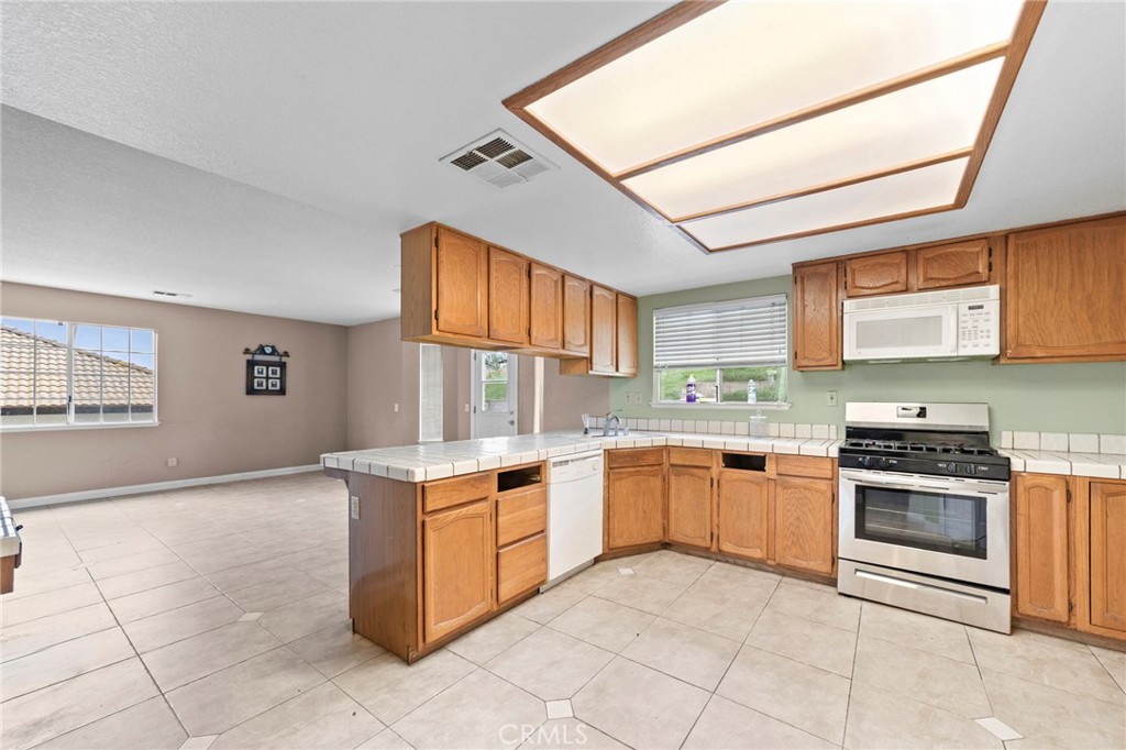 6770 Sandy Lane Riverside, CA 92505 - Photo 10 of 28 a kitchen with stainless steel appliances granite countertop a stove top oven a sink a counter top space and cabinets