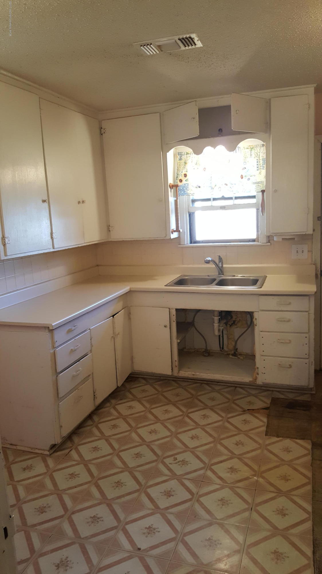 3811 South Tyler Street Amarillo, TX 79110 - Photo 5 of 10 a kitchen with a sink window and cabinets