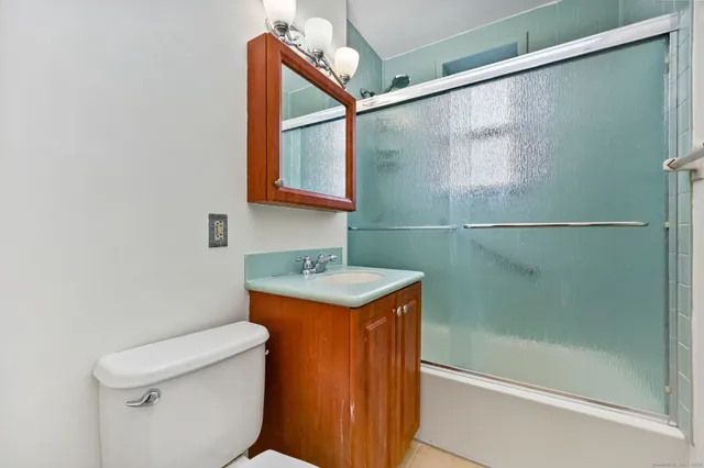 a bathroom with a granite countertop sink toilet and shower