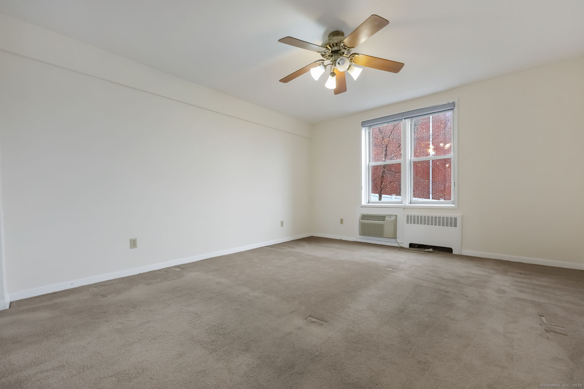 46 Prospect Avenue, Unit 1C Norwalk, CT 06850 - Photo 18 of 24 an empty room with chandelier fan and windows