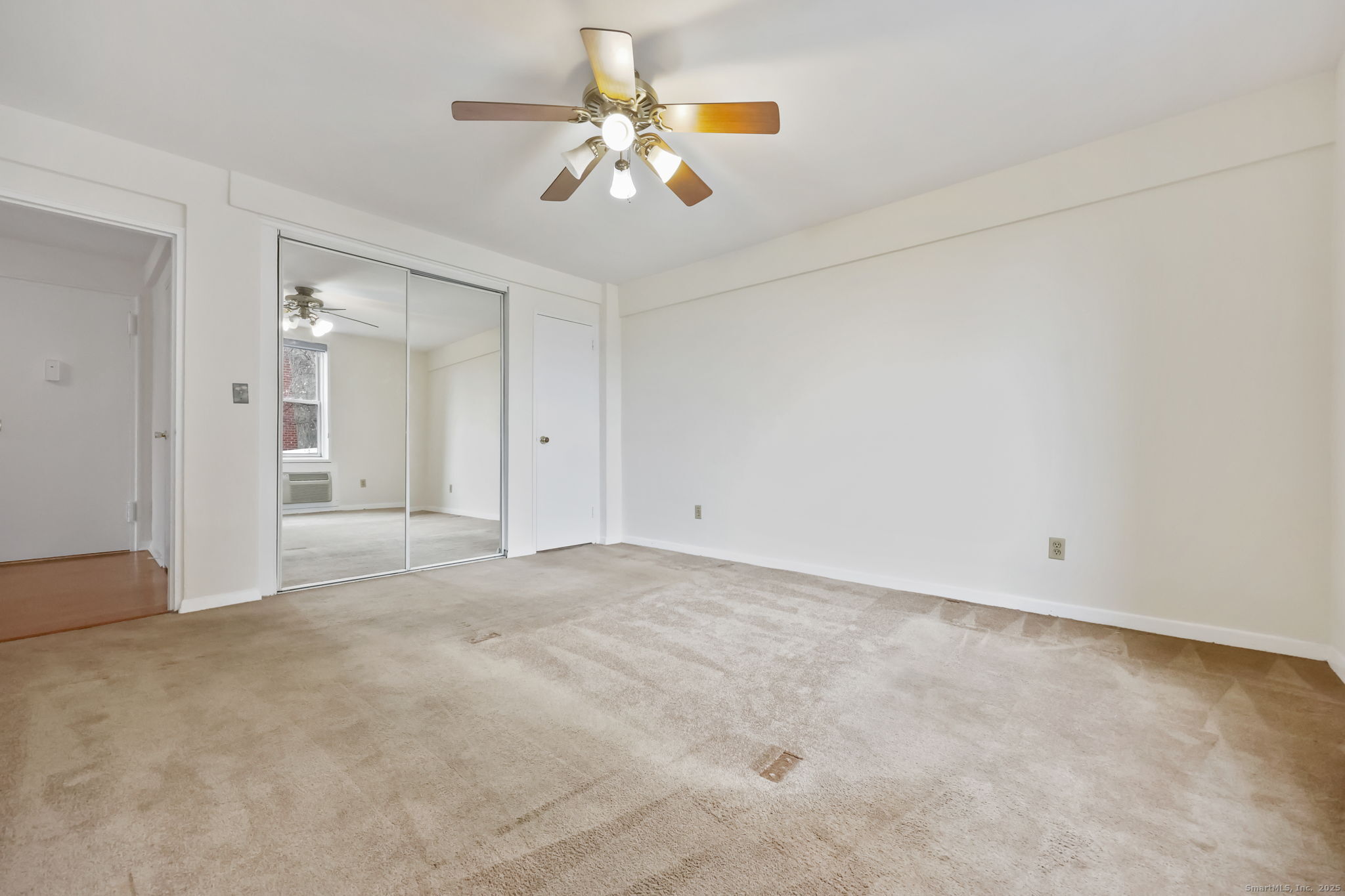 46 Prospect Avenue, Unit 1C Norwalk, CT 06850 - Photo 19 of 24 an empty room with chandelier fan and kitchen view