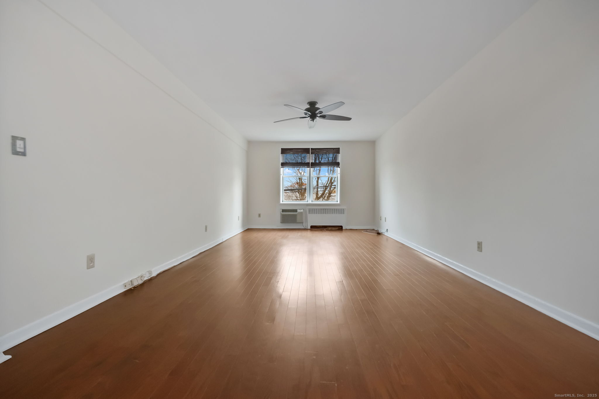46 Prospect Avenue, Unit 1C Norwalk, CT 06850 - Photo 6 of 24 an empty room with a window and wooden floor