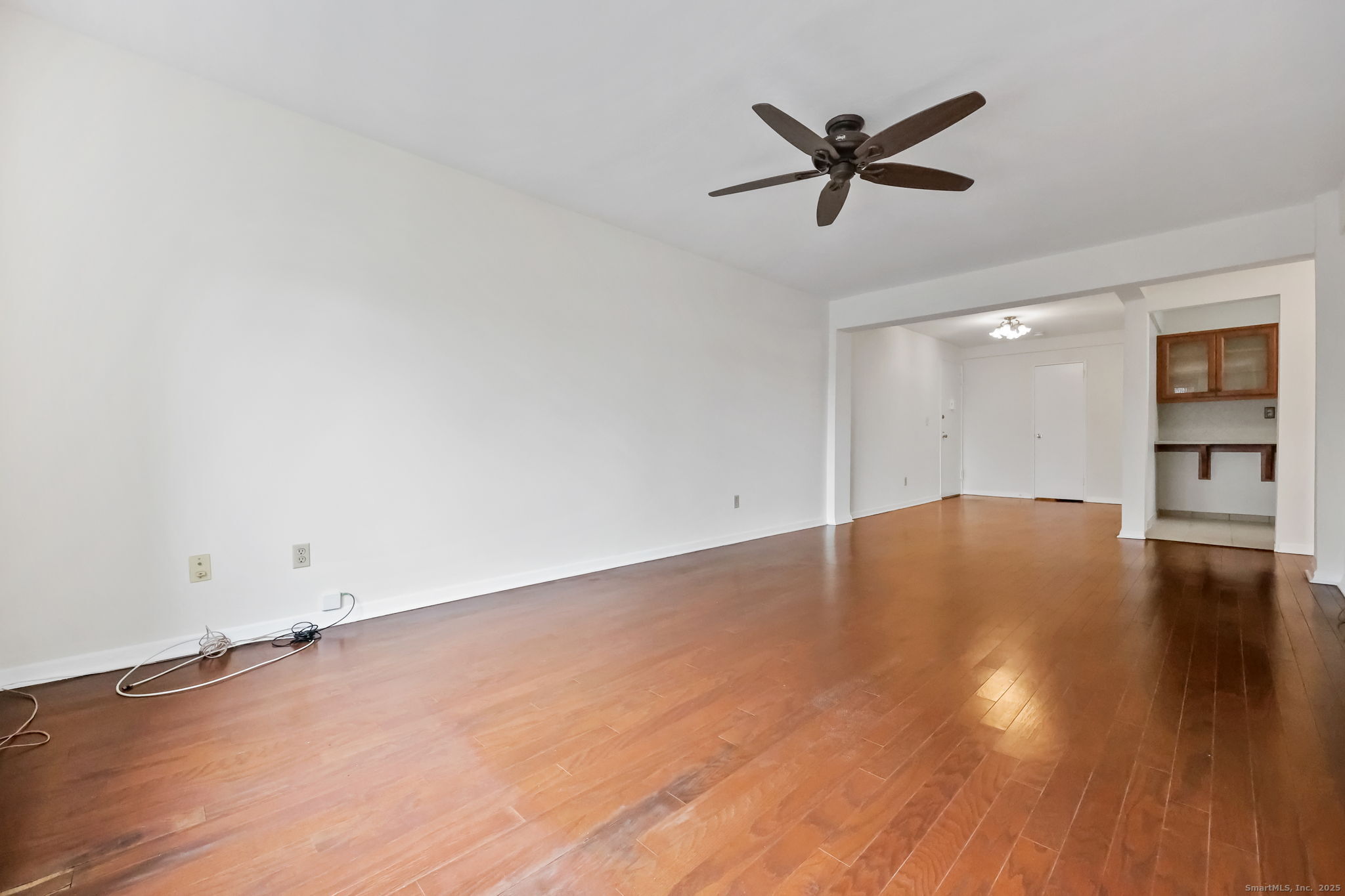 46 Prospect Avenue, Unit 1C Norwalk, CT 06850 - Photo 9 of 24 a view of empty room with wooden floor and ceiling fan