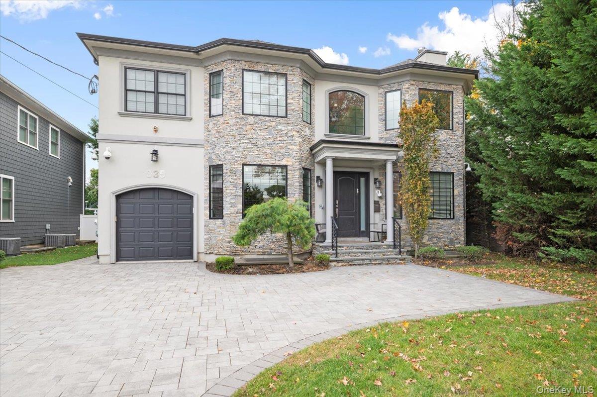 335 Summit Avenue Cedarhurst, NY 11516 - Photo 1 of 43 a front view of a house with a yard and garage