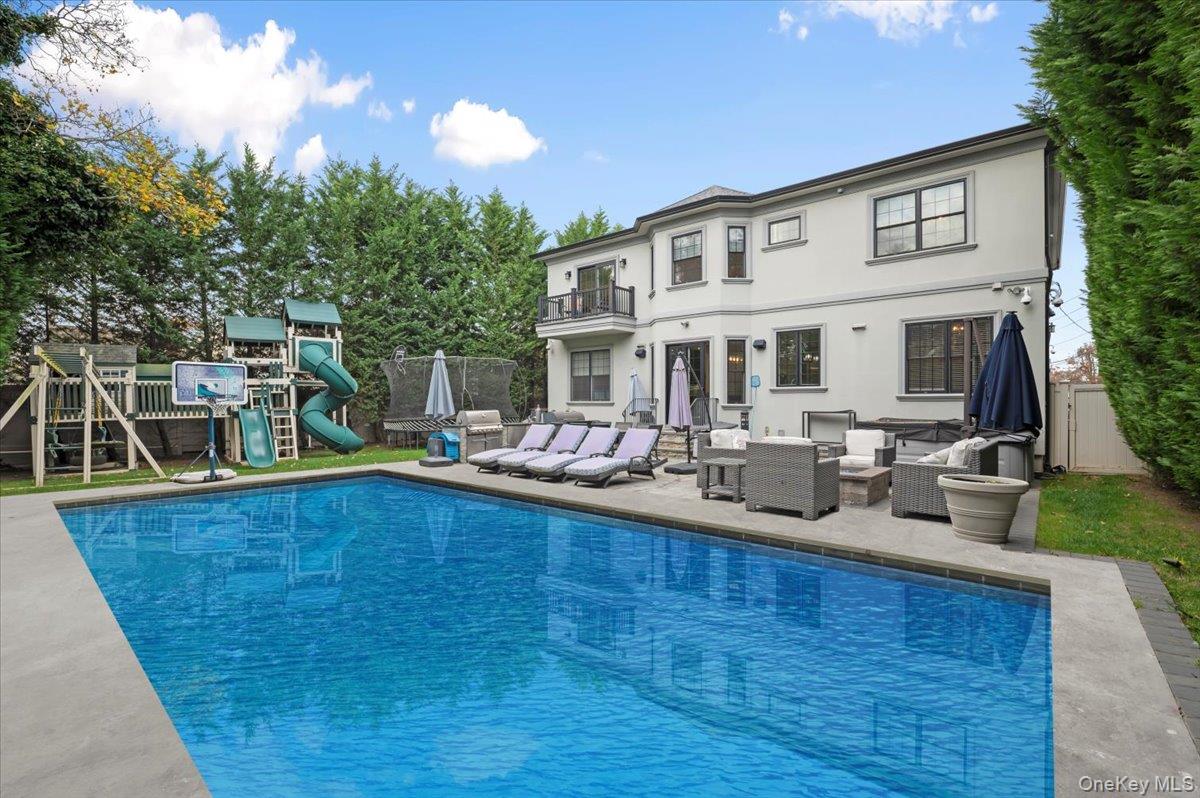 335 Summit Avenue Cedarhurst, NY 11516 - Photo 39 of 43 a view of a house with pool and chairs