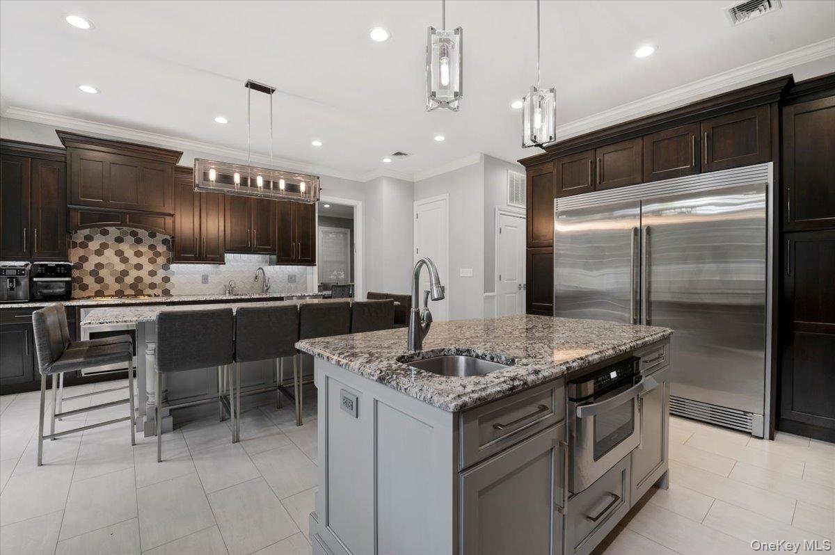 335 Summit Avenue Cedarhurst, NY 11516 - Photo 10 of 43 a kitchen with a table chairs refrigerator and microwave