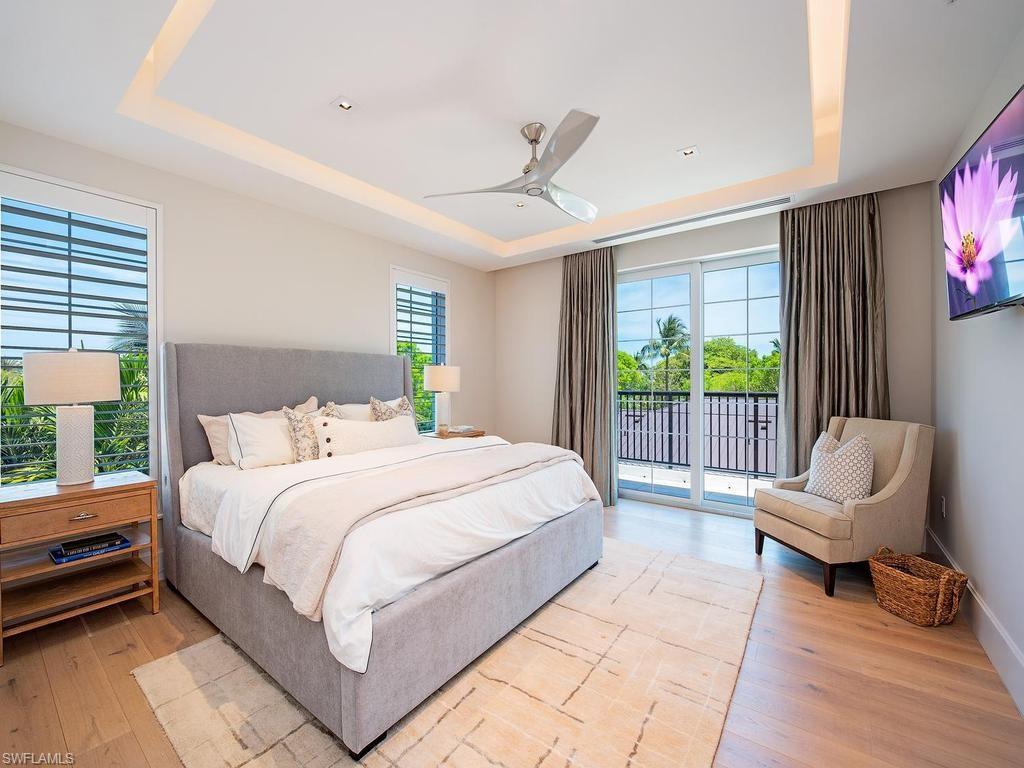 490 5th Street South, Unit 101 Naples, FL 34102 - Photo 17 of 34 a large bedroom with a bed and a couch