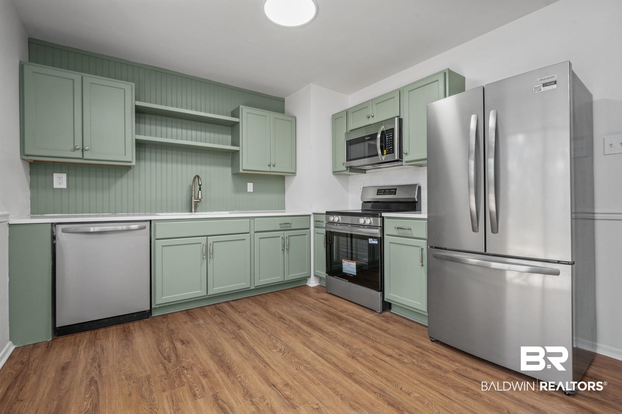 5734 Pheasant Court Theodore, AL 36582 - Photo 7 of 23 Kitchen with green cabinetry, stainless steel appliances, open shelves, and light wood finished floors