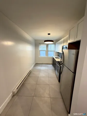 a view of a refrigerator in kitchen and a window