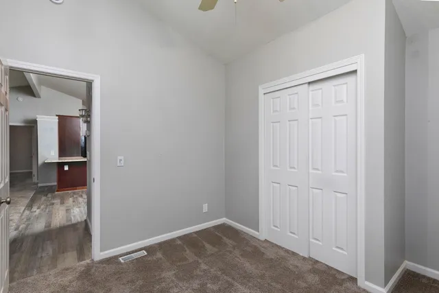 a view of a house with a yard and table and chairs under an umbrella