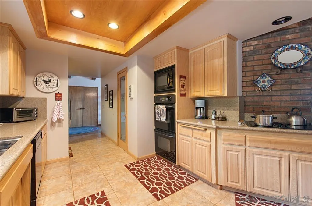 7631 Rancho Amigos Road North Bonsall, CA 92003 - Photo 8 of 26 a kitchen with stainless steel appliances granite countertop a sink and cabinets