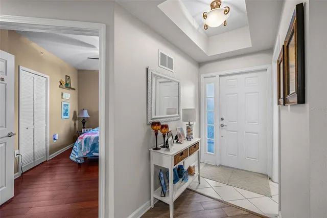 a view of a hallway to room with wooden floor and furniture