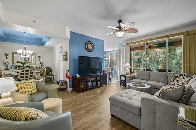 a living room with furniture a ceiling fan and a large window