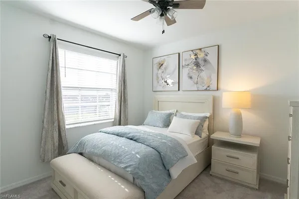 a bedroom with a bed and a painting on the wall
