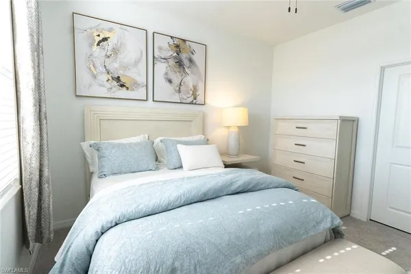 a bedroom with a bed and painting on the wall