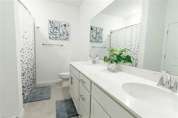 a bathroom with a granite countertop sink mirror vanity and toilet