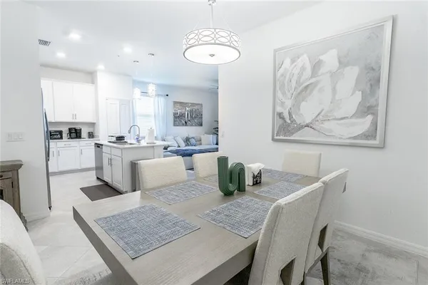 a dining room with wooden floor a chandelier a wooden table and chairs