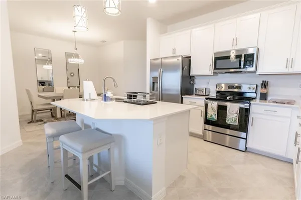 a kitchen with stainless steel appliances a stove a sink island and a refrigerator