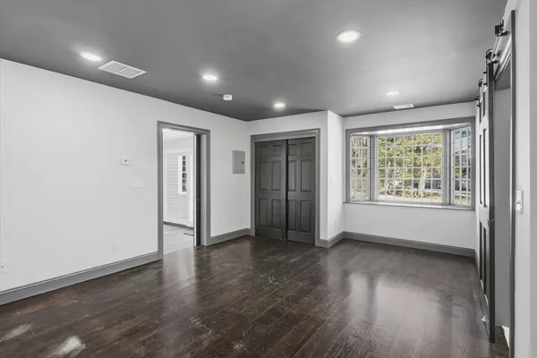 an empty room with wooden floor and windows
