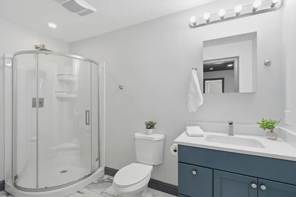 a bathroom with a sink a toilet and shower