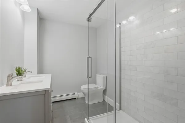 a bathroom with a sink a toilet and shower