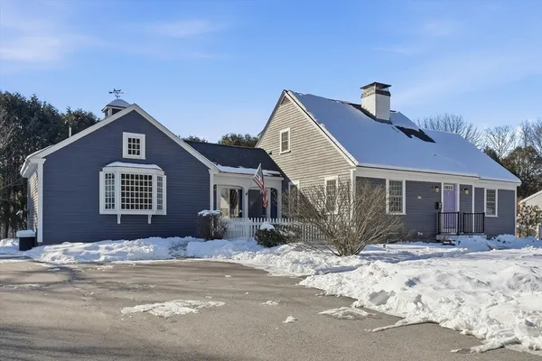 a front view of a house with a yard covered in snow