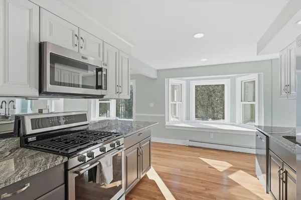 a kitchen with stainless steel appliances granite countertop a stove a microwave and a sink