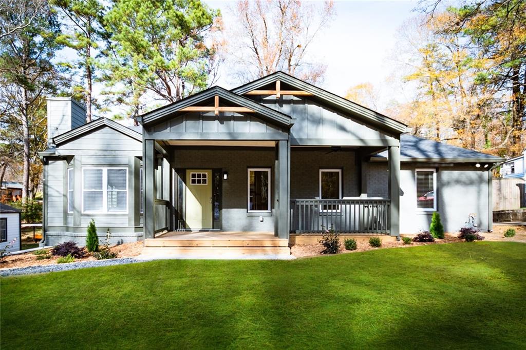 a view of a house with a yard patio and a tree