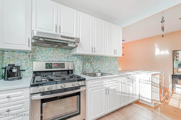 a kitchen with white cabinets and appliances